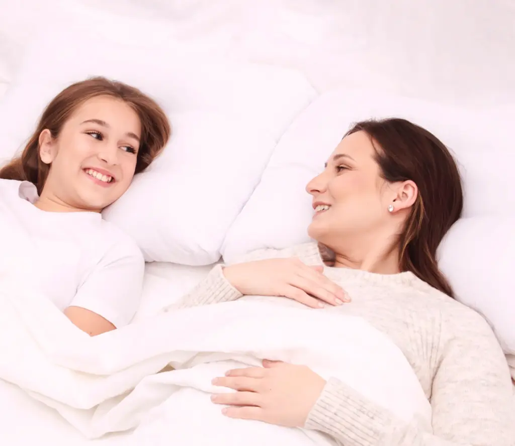 Deux personnes souriantes parlent au lit.