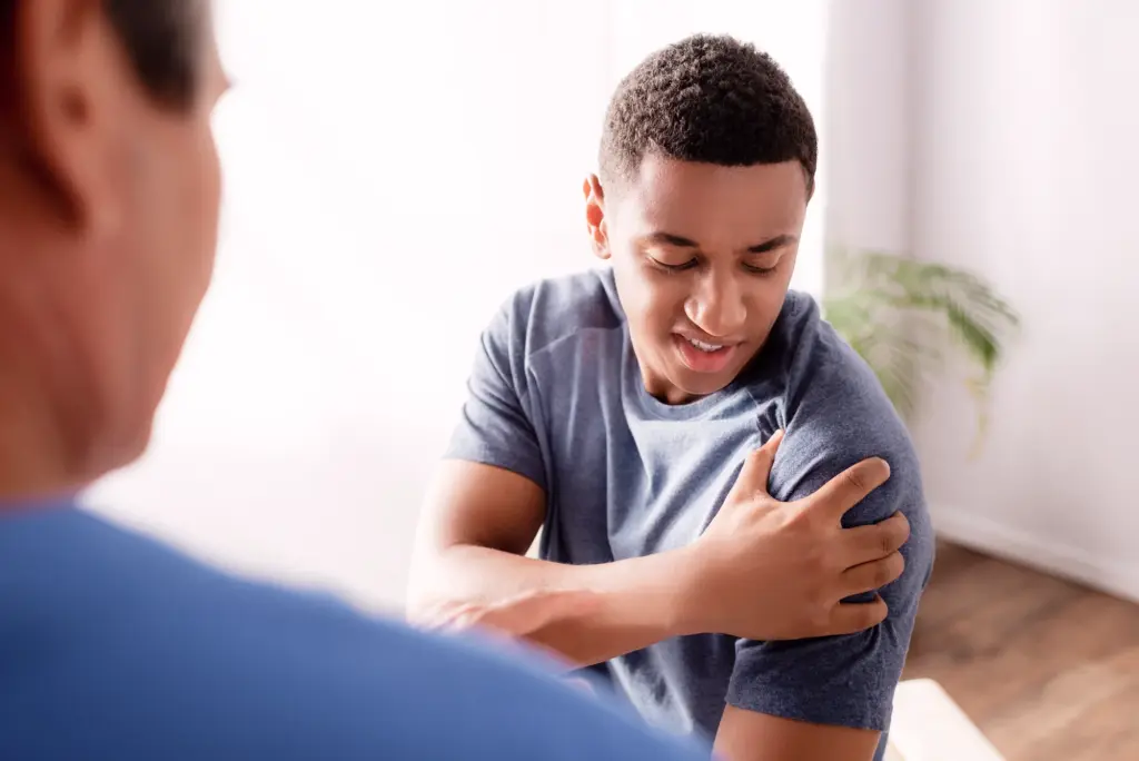 Médecin expliquant modèle anatomique de la colonne vertébrale.