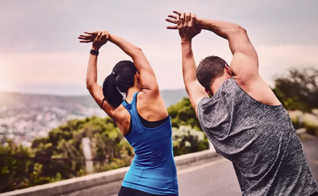Deux personnes s'étirent en plein air.
