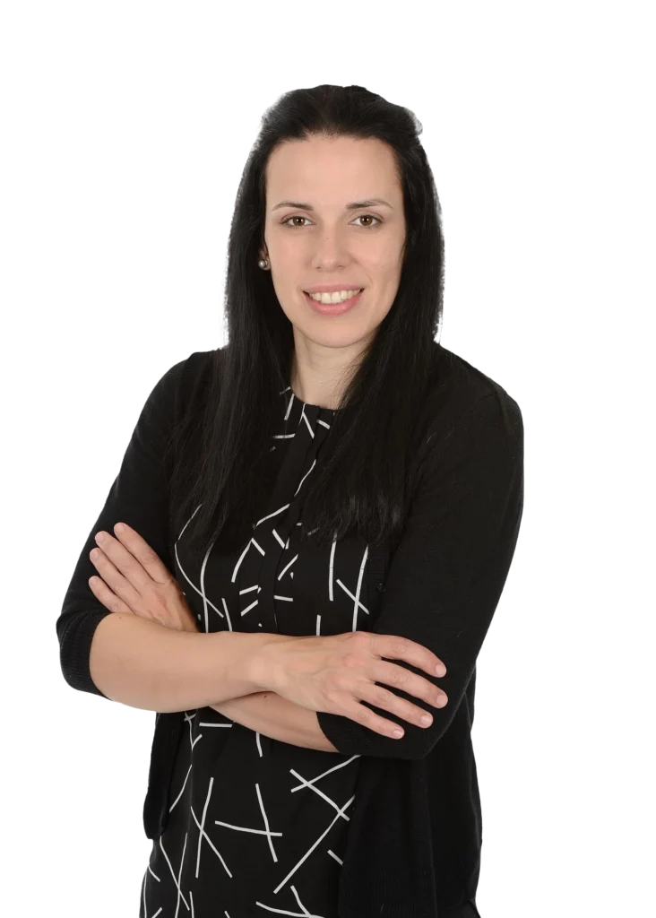 Femme souriante bras croisés en noir et blanc.